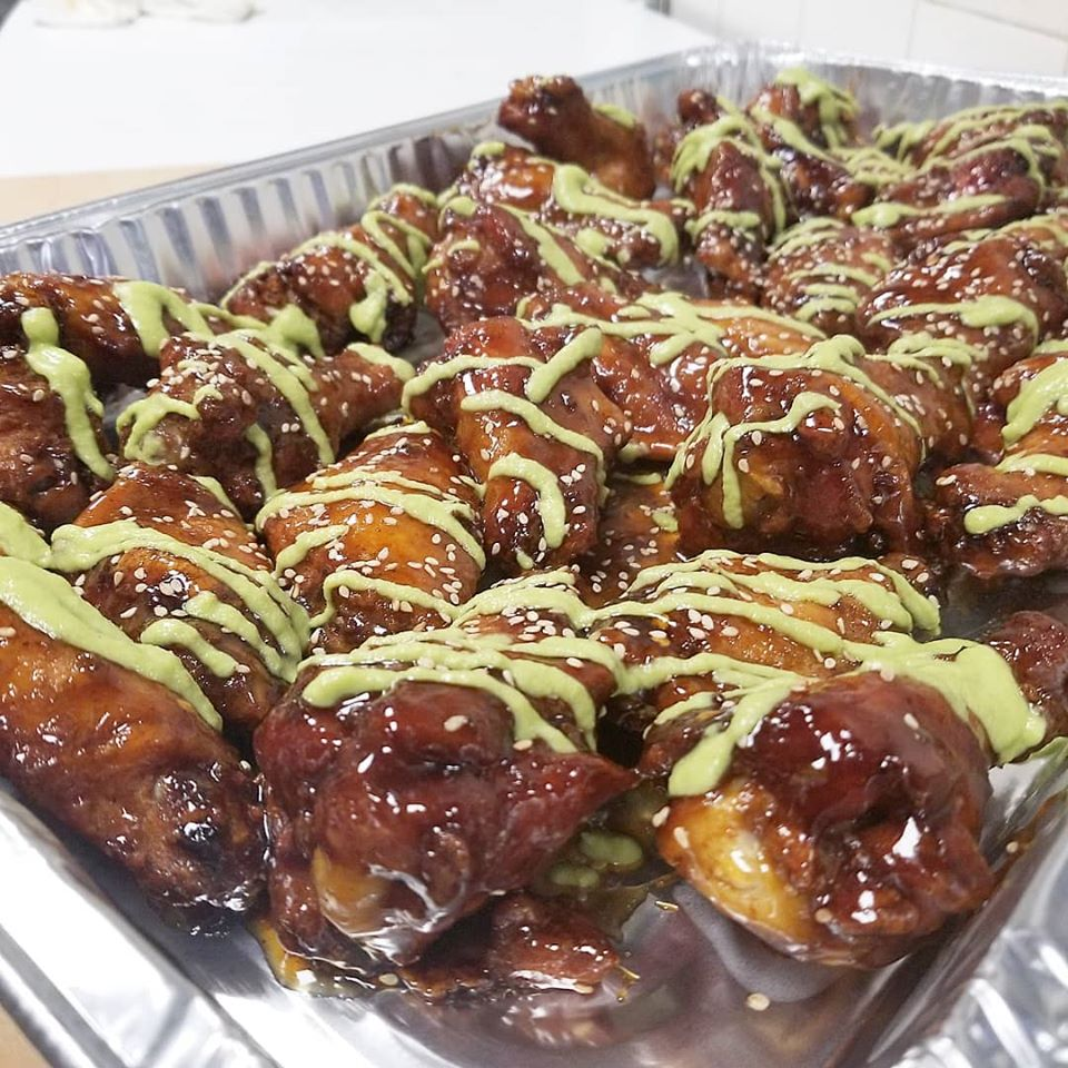 Glazed wings with sesame seeds and a green sauce drizzle